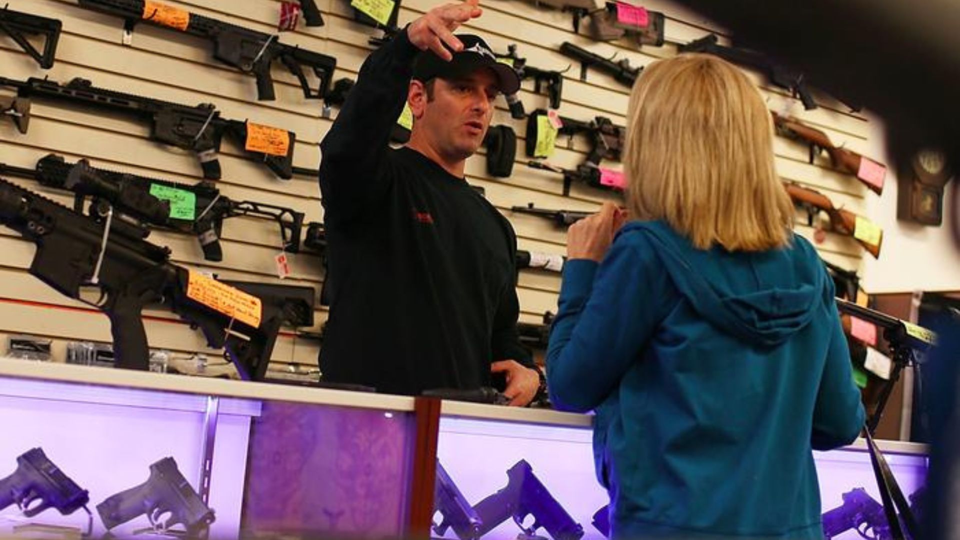 a lady purchasing a gun from a man